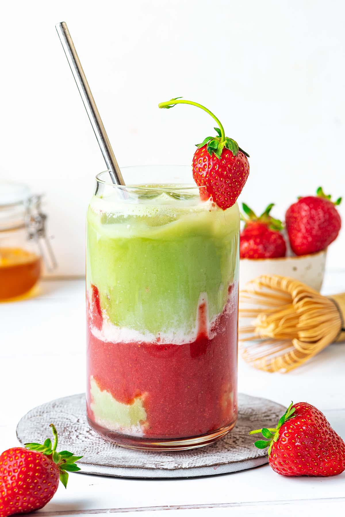 Strawberry Matcha Latte in a serving glass decorated with fresh strawberry