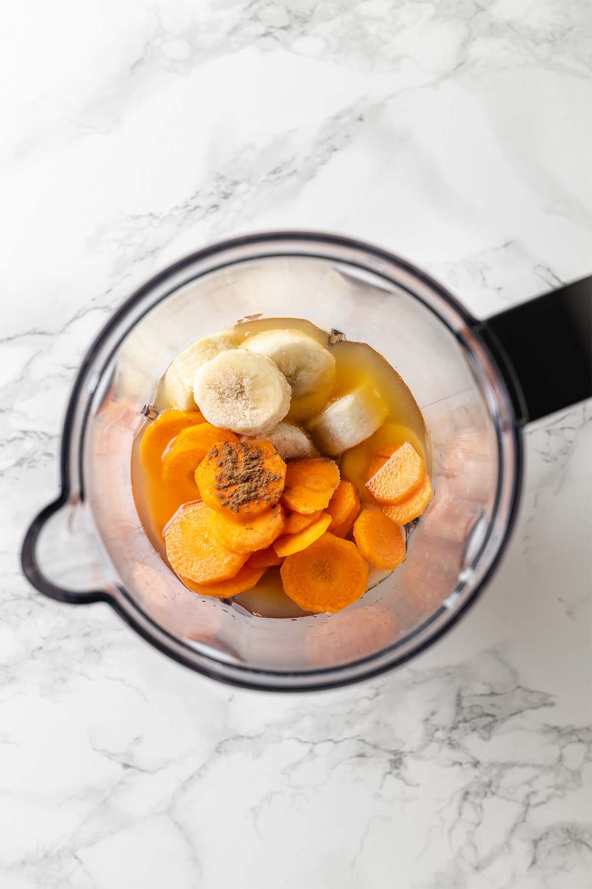 Ingredients for carrot banana smoothie in a blender