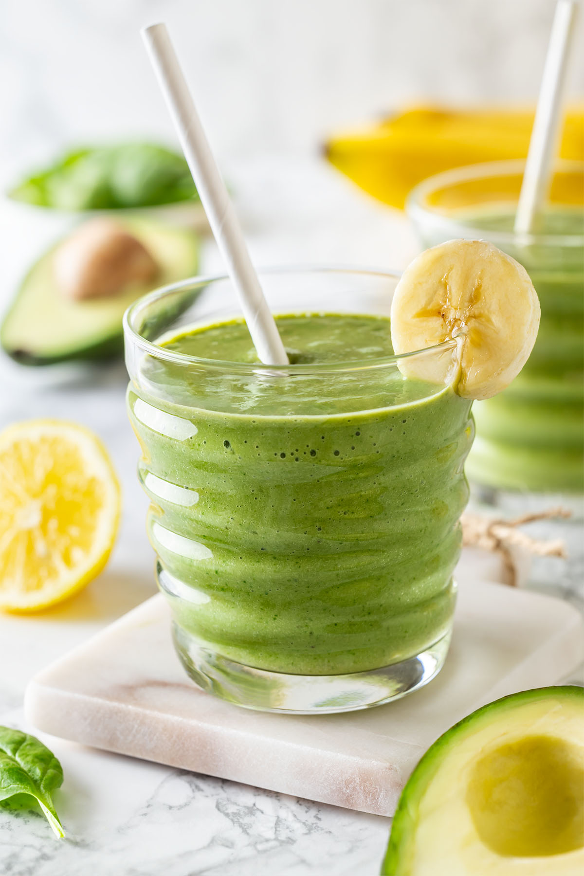Green smoothie with banana and avocado with a straw