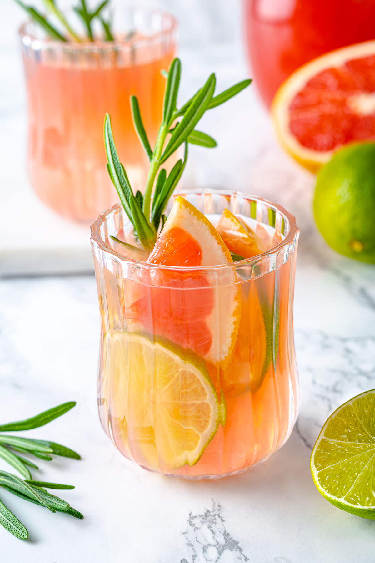Grapefruit lime drink in a glass with rosemary