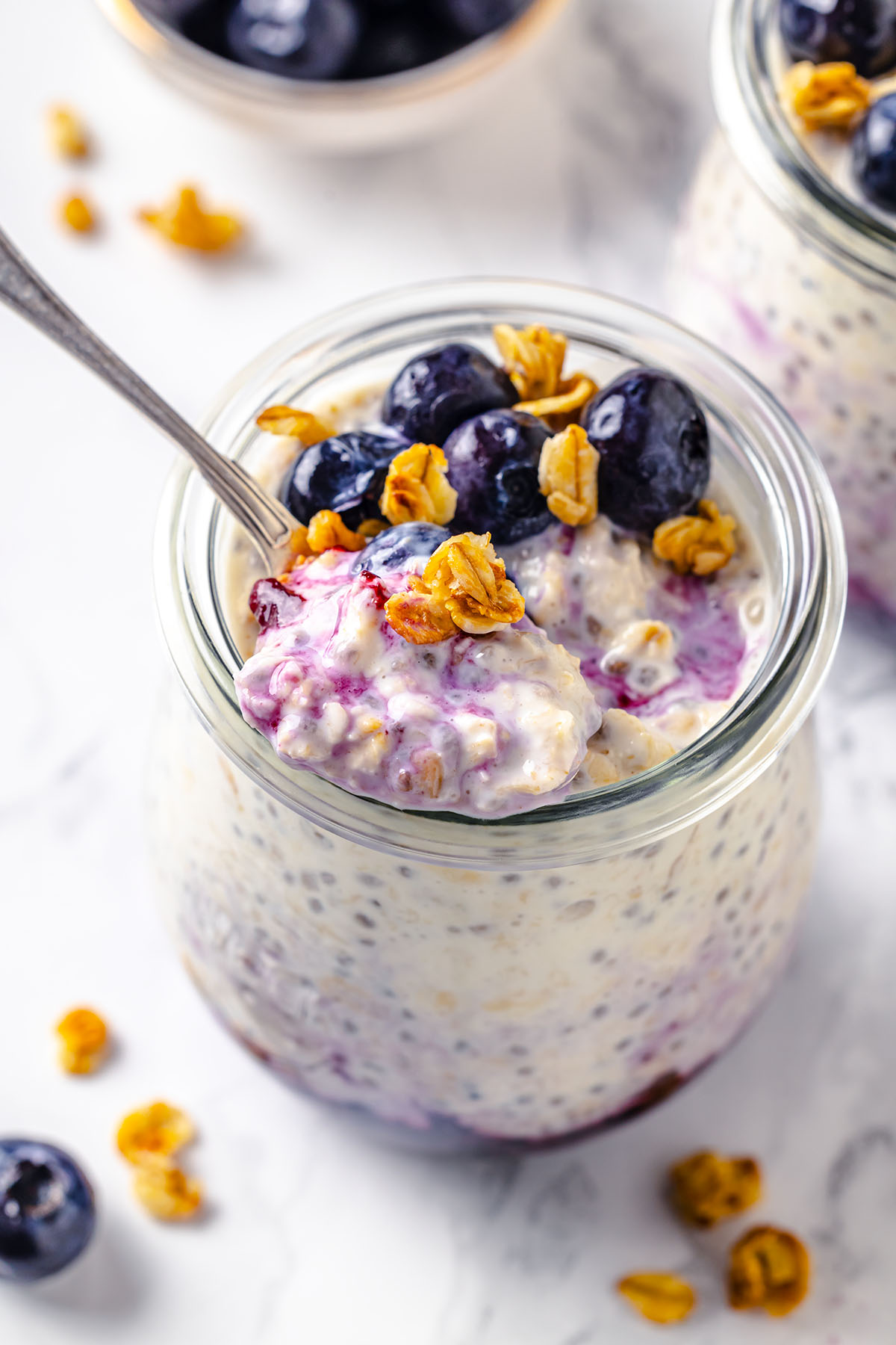 Spoon with blueberry cheesecake overnight oats