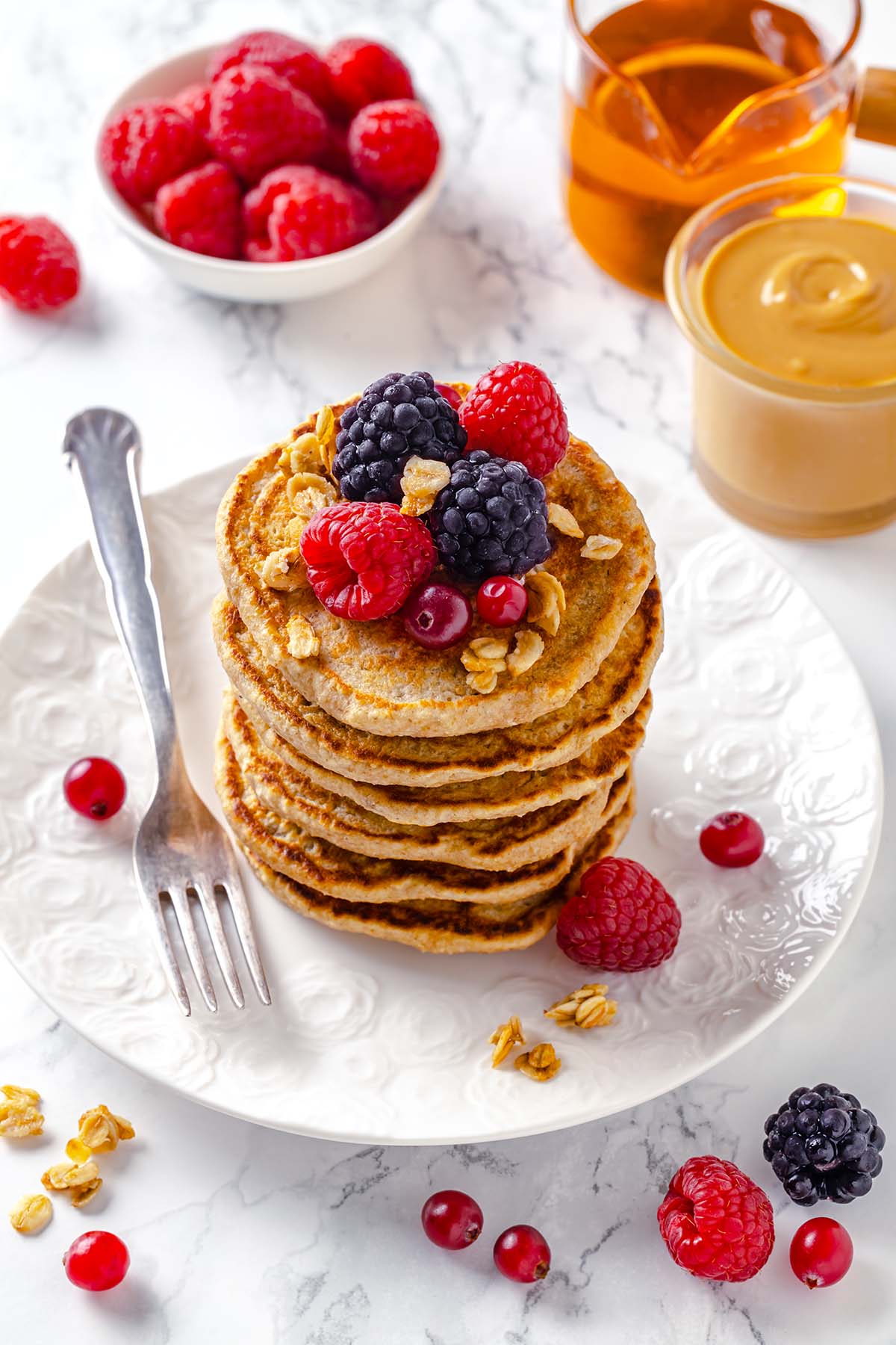 Stack of peanut butter oatmeal pancakes decorated with berries