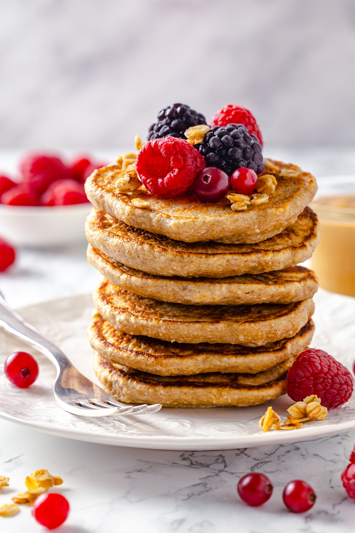 Stack of peanut butter oatmeal pancakes decorated with berries