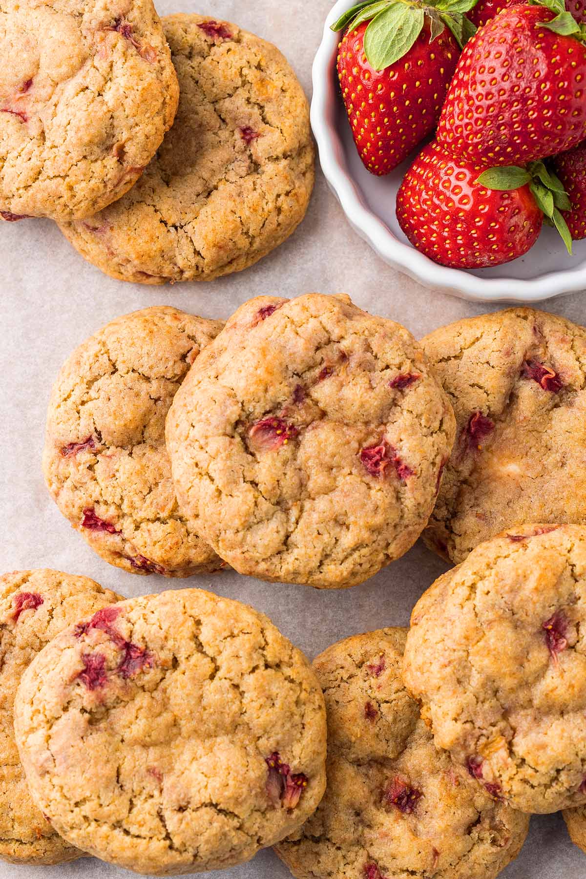 Strawberry cheesecake cookies and a bowl with fresh strawberries