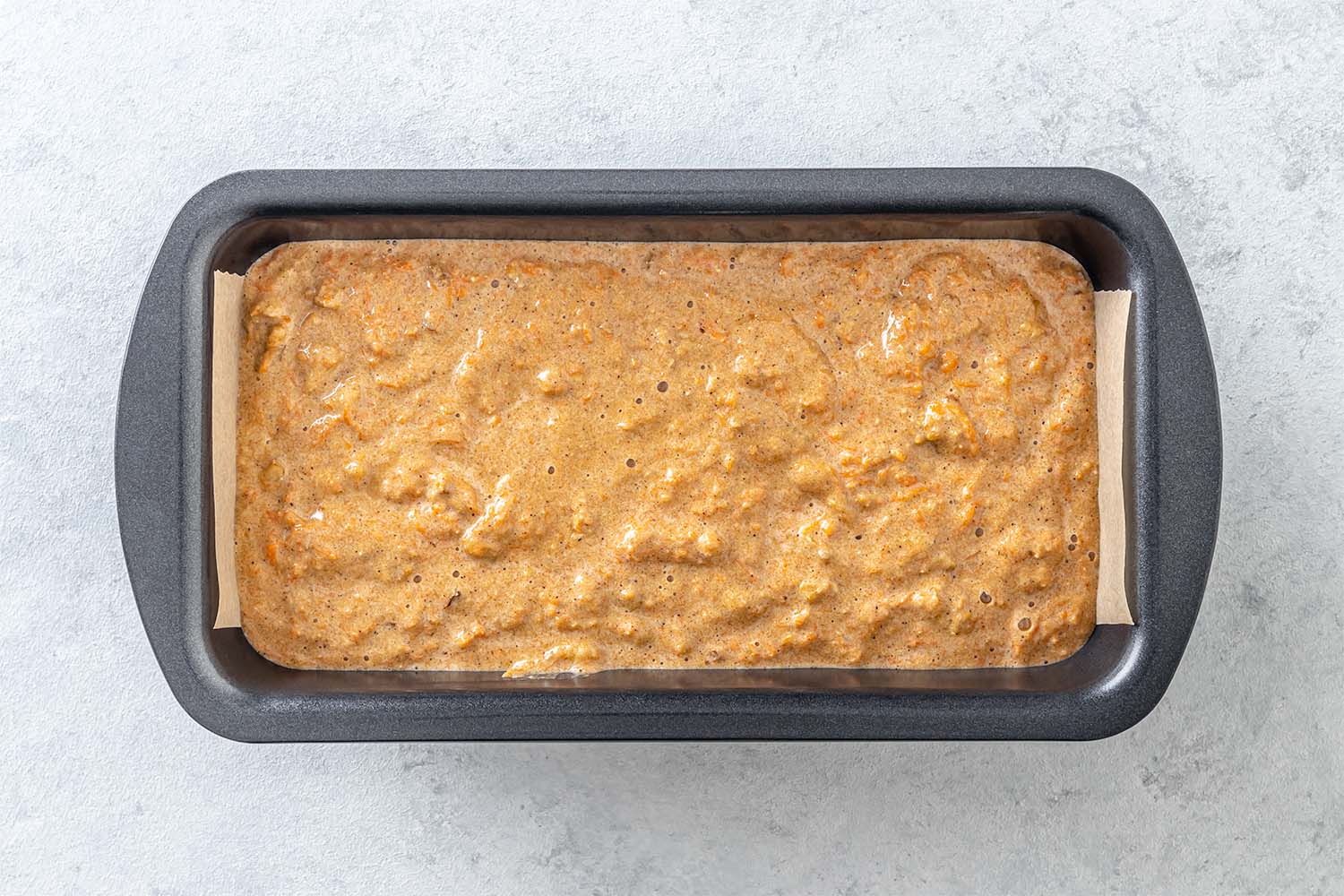 Batter for carrot cake in a loaf pan
