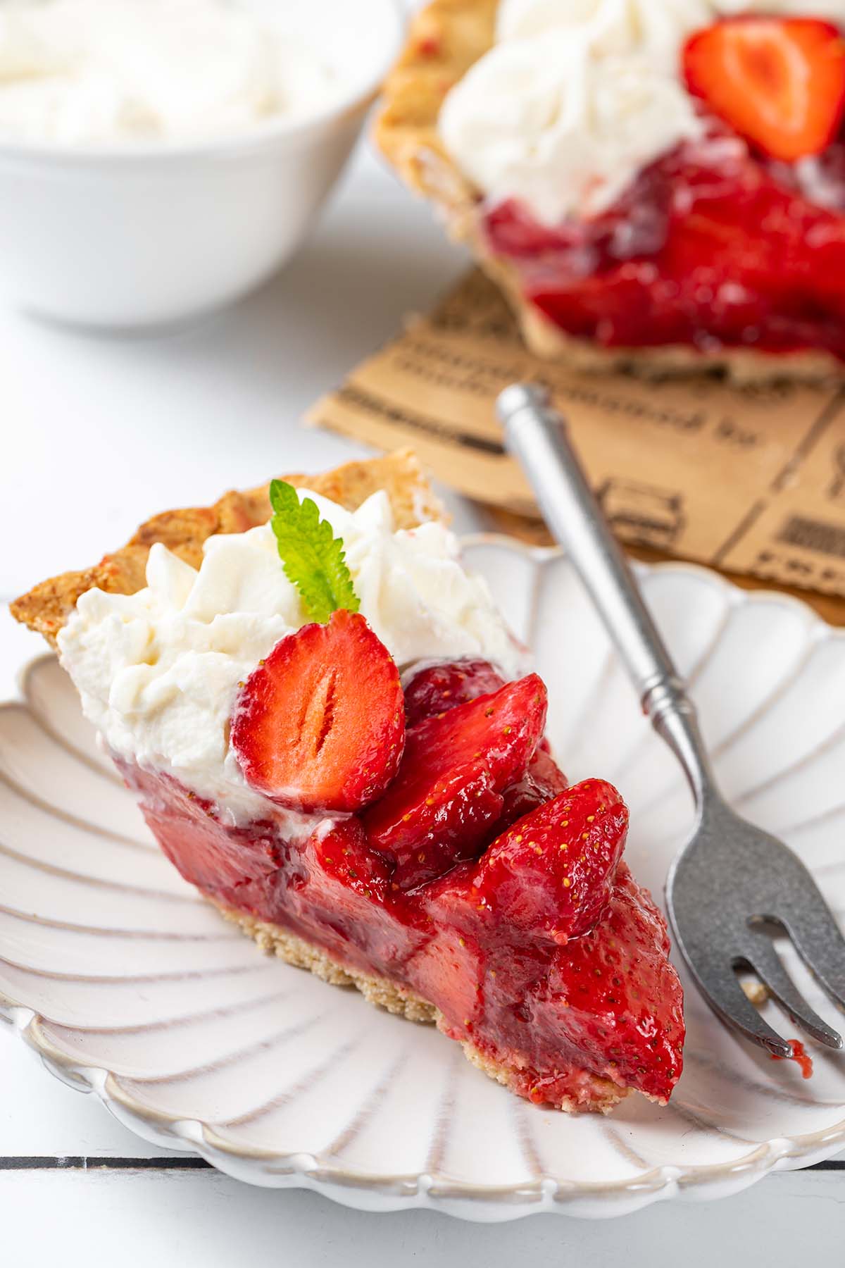 A slice of strawberry pie on a plate with a fork