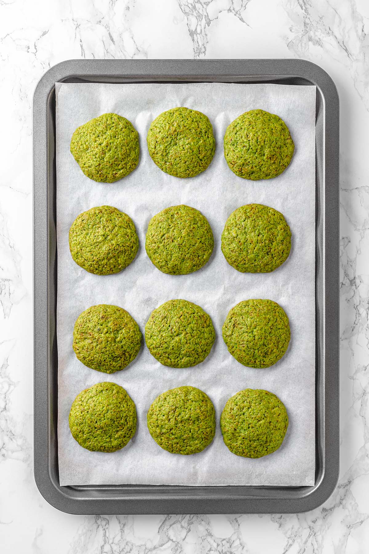 Green cookies on a baking sheet