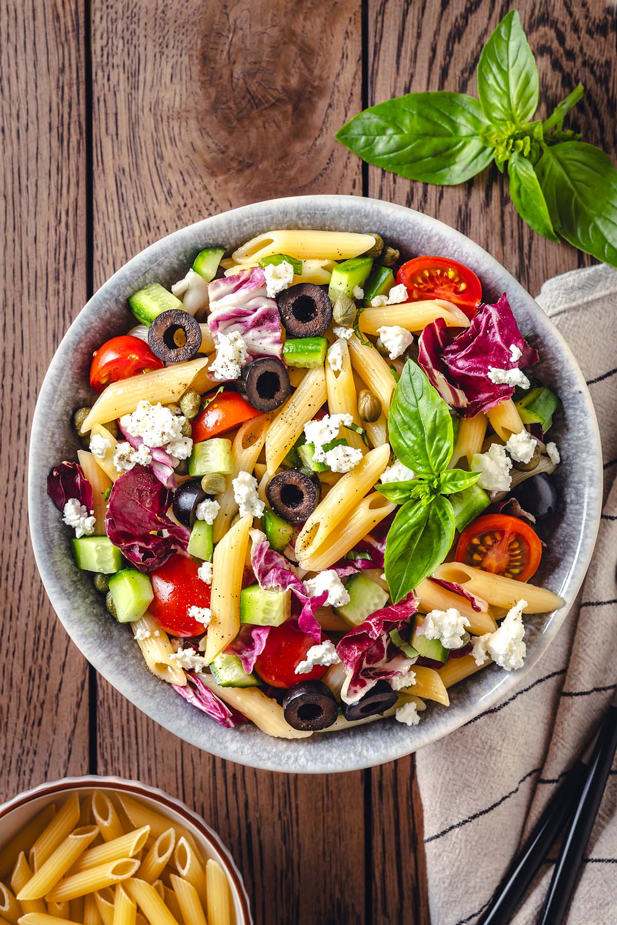 The bowl with Sicilian pasta salad decorated with fresh basil
