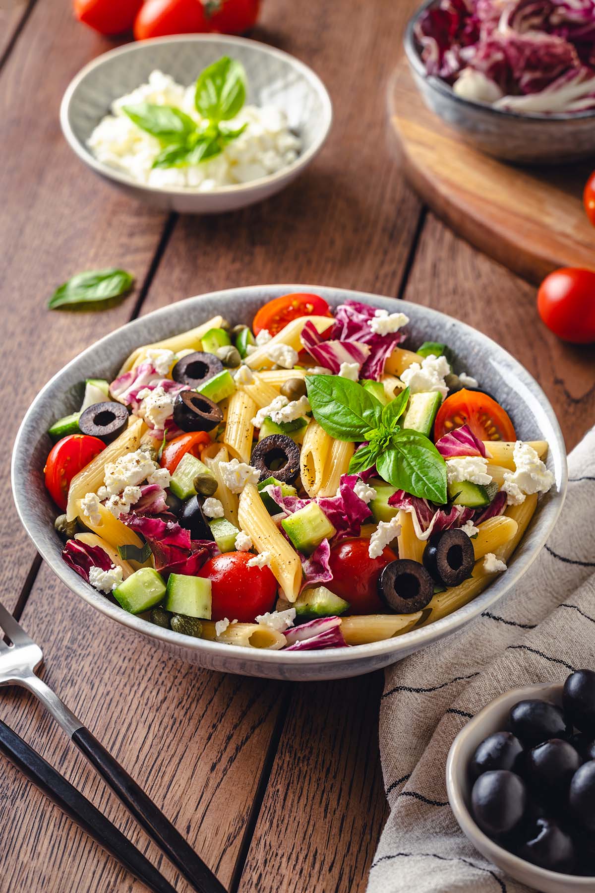 The bowl with Sicilian pasta salad on a rustic wooden table