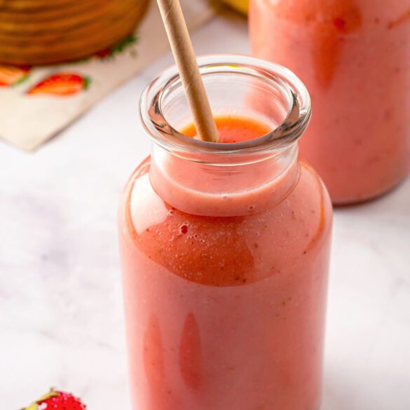 Bottles of strawberry apple smoothie with straw inside