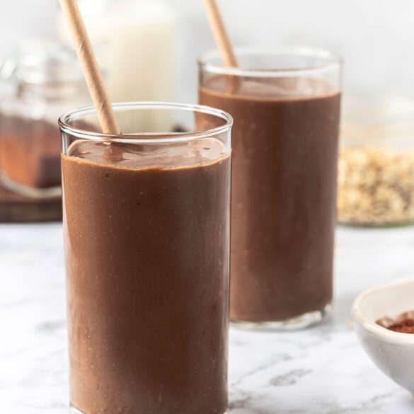 Two glasses with chocolate smoothie with straws inside